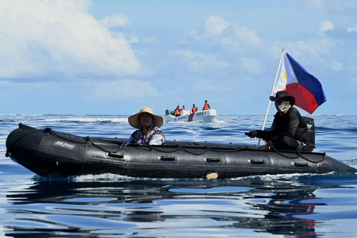 Philippine Navy personnel onboard a rigid inflatable boat blocking a China Coast Guard aluminum hulled boat at Second Thomas Shoal on Nov 10.