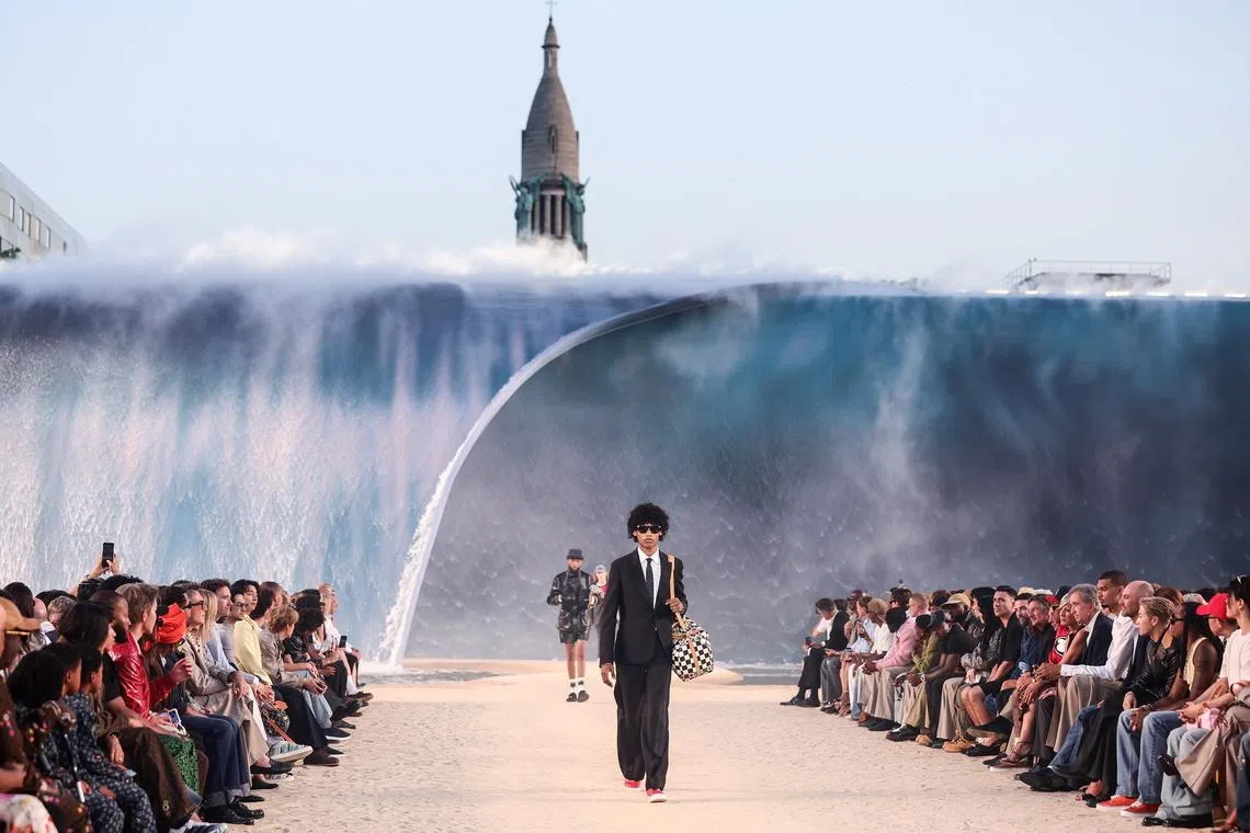 Models wore an eclectic mix of denim, hoodies and flashy jackets as they walked over sand.