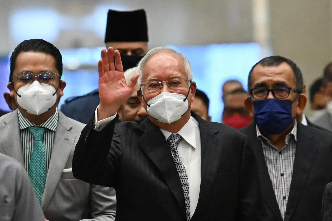Malaysia's former prime minister Najib Razak (C) waves as he arrives at the federal court in Putrajaya on August 23, 2022.
