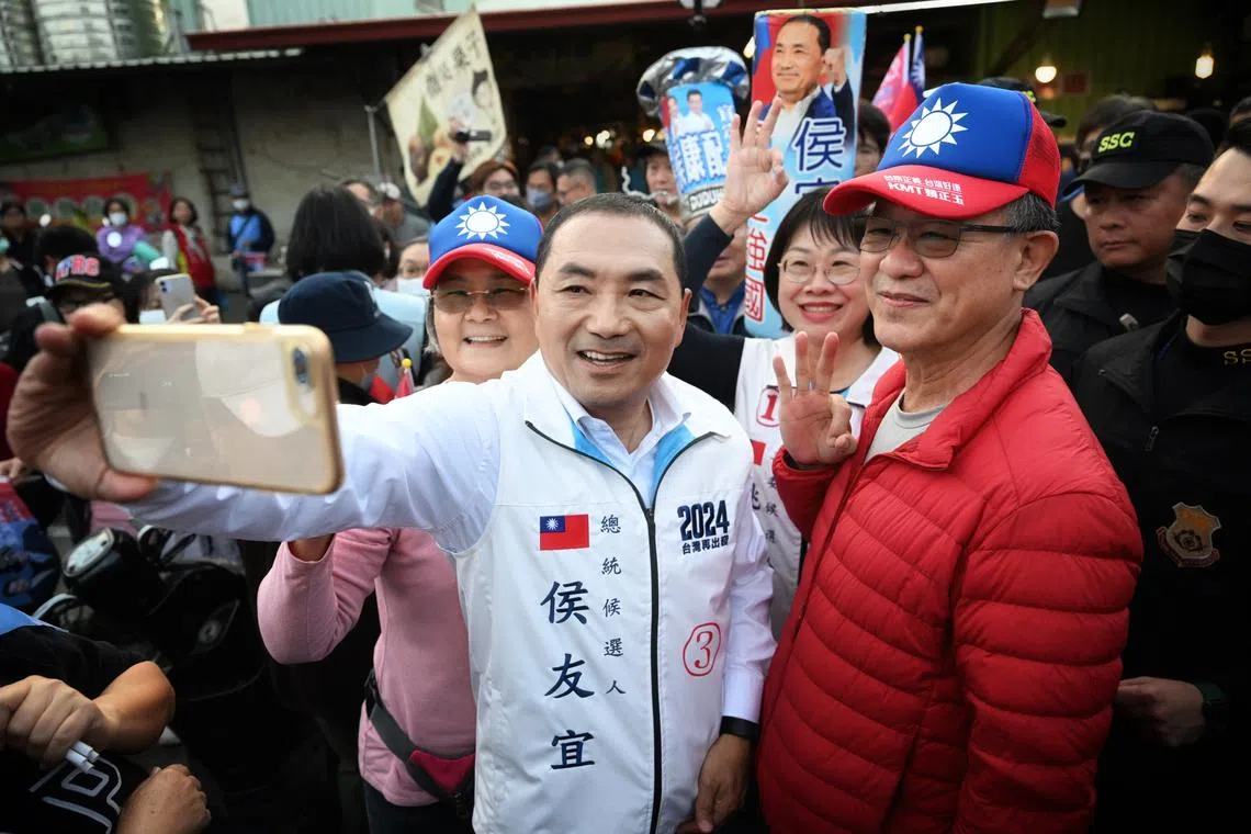 KMT presidential candidate Hou Yu-ih taking a wefie with supporters at a market in Tainan on Jan 8.