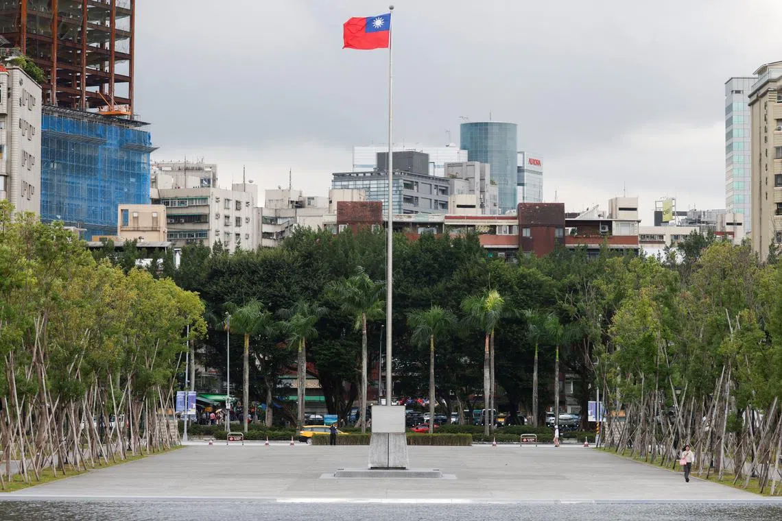 A person walks next to a fluttering Taiwanese flag outside the Sun Yat-Sen Memorial Hall in Taipei, Taiwan November 16, 2023. REUTERS/Carlos Garcia Rawlins/File Photo
