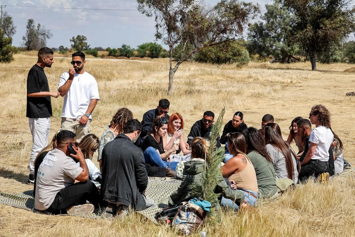 Survivors of the October 7 attack on the Supernova music festival gather after returning to the site near Kibbutz Reim in southern Israel on April 10.