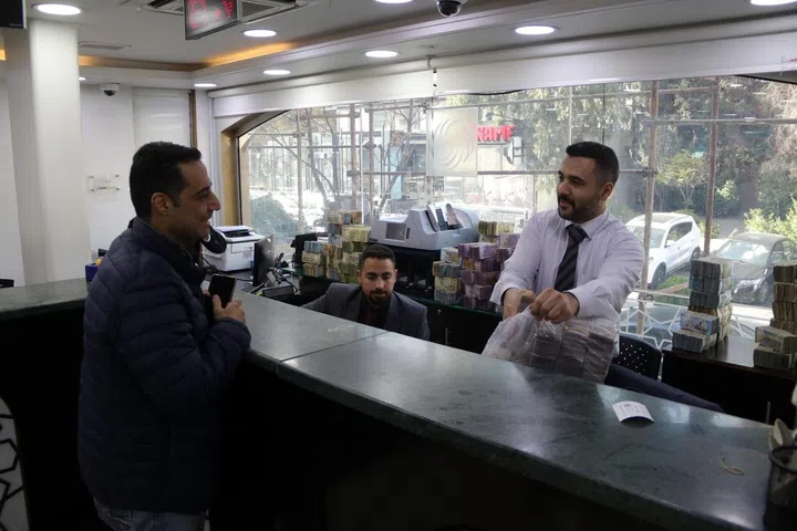 epa11768809 Um cliente conversa com um funcionário de um banco local em Damasco, Síria, 10 de dezembro de 2024. Os bancos na capital síria, Damasco, retomaram as operações após a deposição do presidente Bashar al-Assad. EPA-EFE/HOSSAM DARAYA