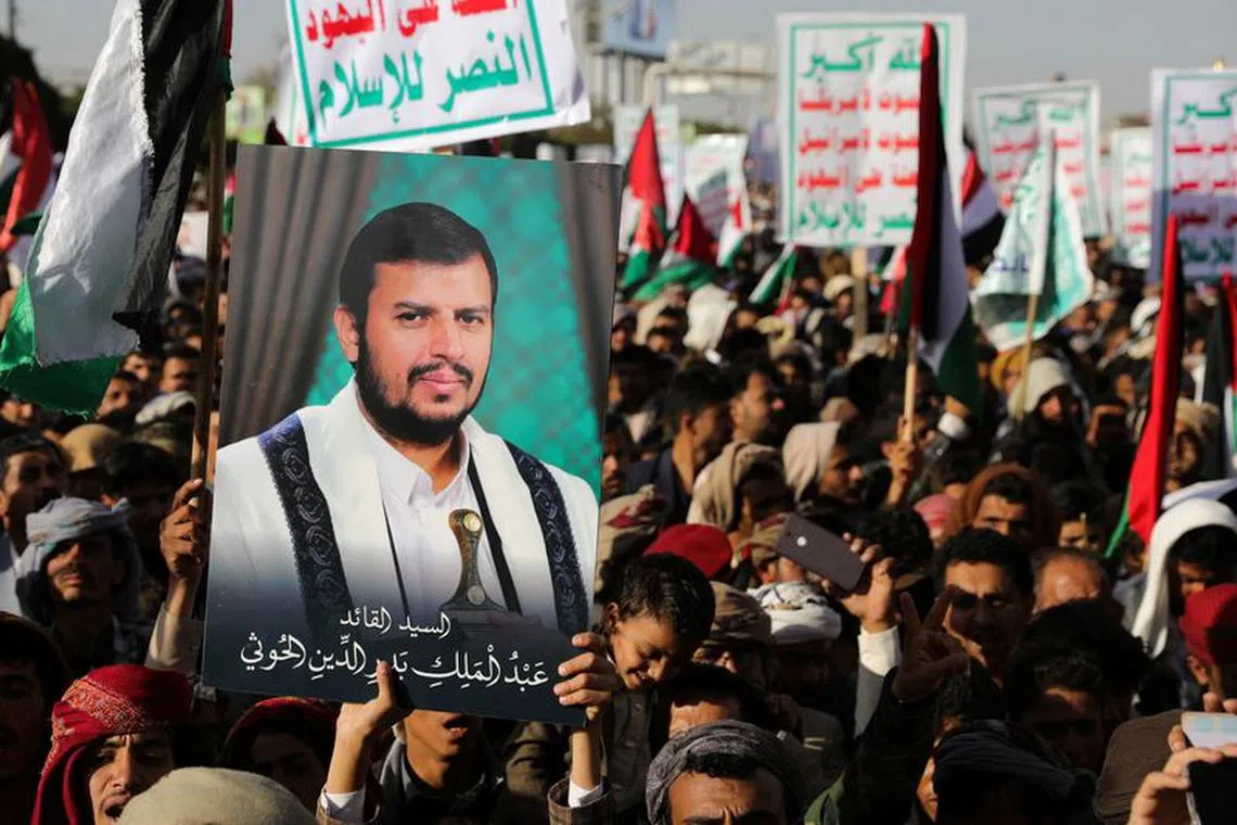 A person holds a placard with a picture of Yemen's Houthi movement leader Abdul-Malik al-Houthi, as supporters of the Houthi movement rally to denounce air strikes launched by the U.S. and Britain on Houthi targets, in Sanaa, Yemen January 12, 2024. REUTERS/Khaled Abdullah