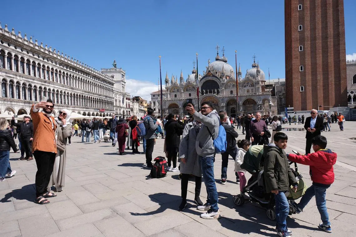 FILE PHOTO: Tourists walk in St Mark's Square on the day Venice municipality introduces a new fee for day trippers in a move to preserve the lagoon city often crammed with tourists in Venice, Italy, April 25, 2024. REUTERS/Manuel Silvestri/File Photo