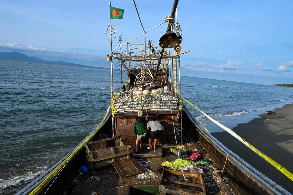 People at Lamnga beach in Aceh province, Indonesia, inspecting a dilapidated boat that was used by the Rohingya refugees.