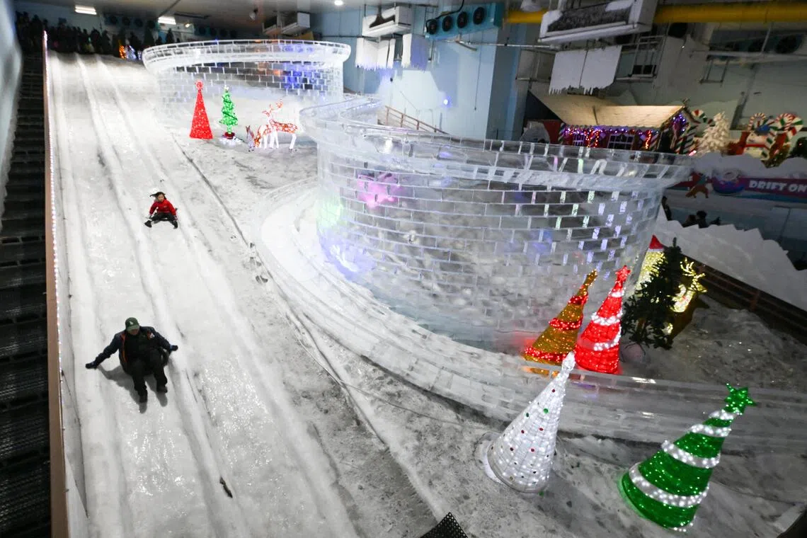 Visitors gliding down a 60m-long snow slide.