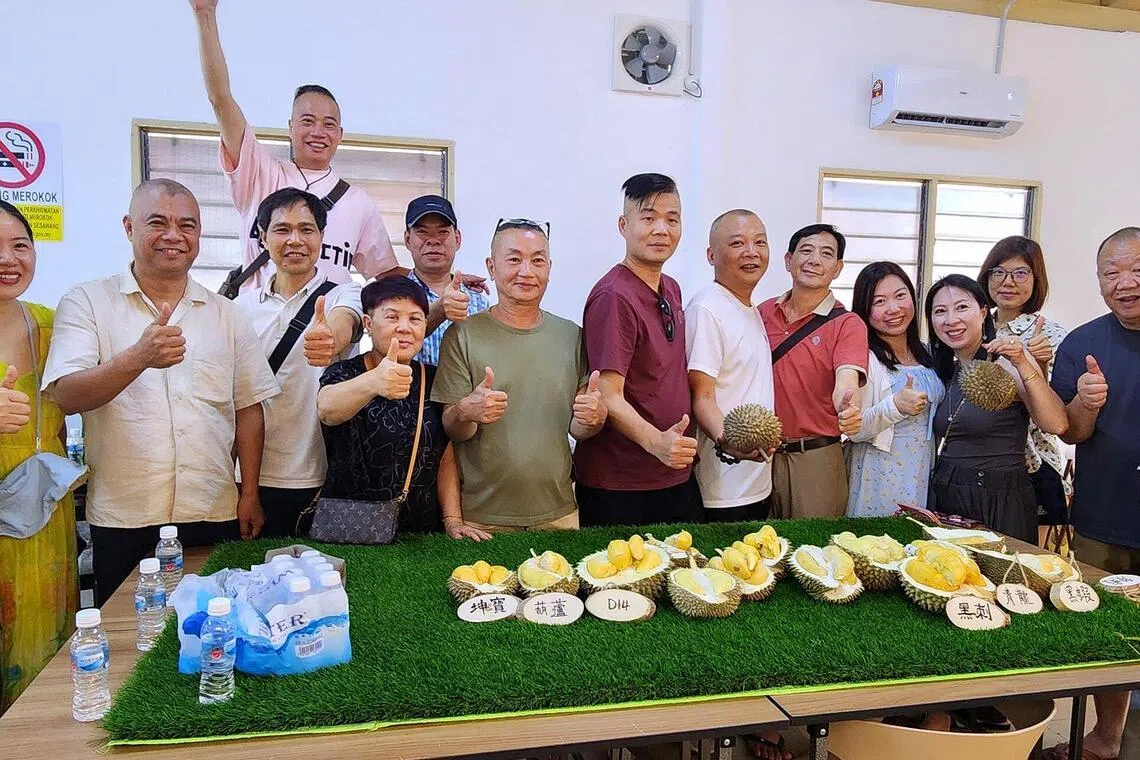 Tourists from China enjoy a durian omakase experience in Penang, sampling the king of fruits in a curated tasting session on July 1, with Steven Yam of Durian Tasting Home (right).