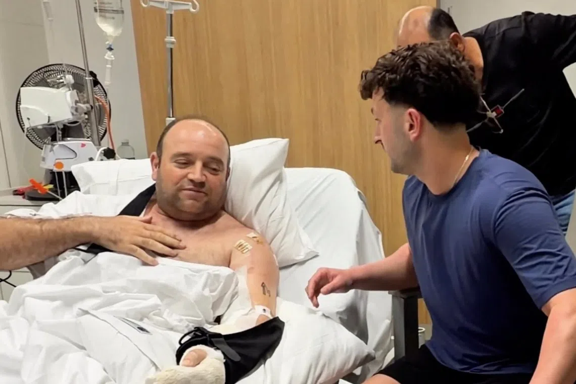 Influencer Zachery Dereniowski gives a check of A$2,533,585 to Mr Ahmed al Ahmed, the bystander who is hailed as the "Bondi hero".