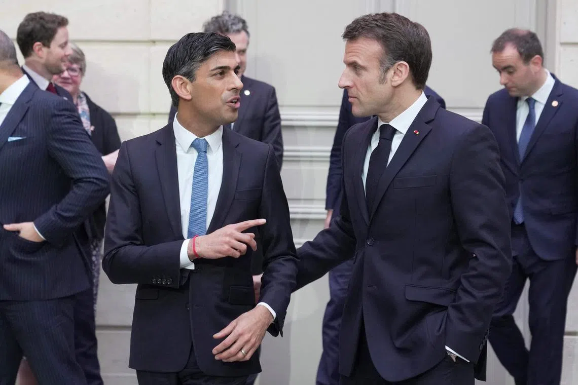 France's President Emmanuel Macron (right) speaking to British PM Rishi Sunak at the Elysee Palace in Paris on March 10, 2023.