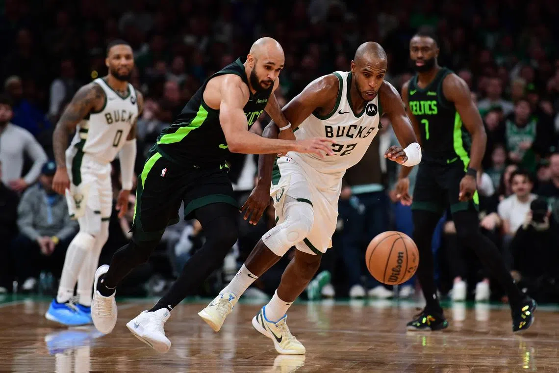 Boston Celtics guard Derrick White and Milwaukee Bucks forward Khris Middleton battle for a loose ball during the second half at TD Garden.