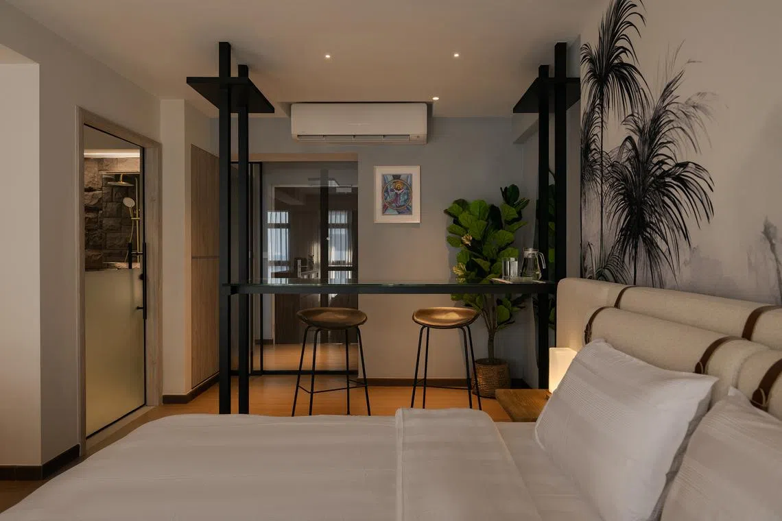 The reconfigured layout merges the sleeping and living zones into an open-plan suite with a glass bar counter.