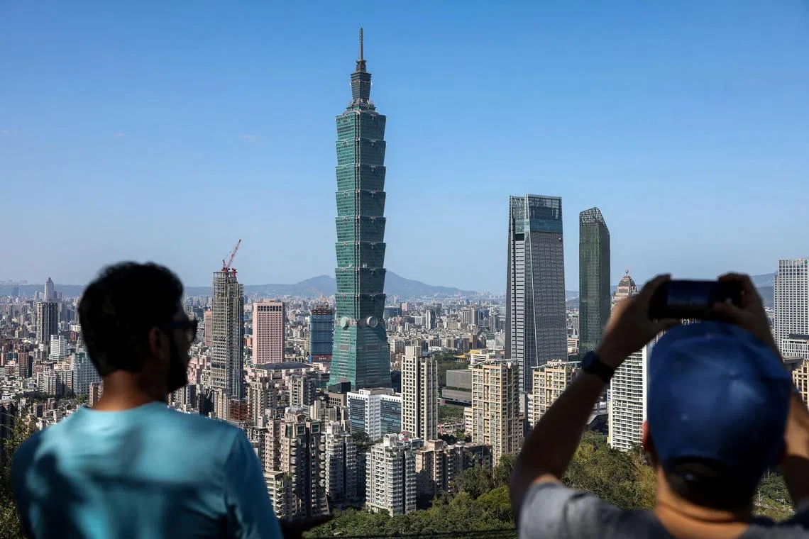 Visitors take pictures of Taipei city from the top of Elephant Mountain in Taipei on November 29, 2024. (Photo by I-Hwa CHENG / AFP)