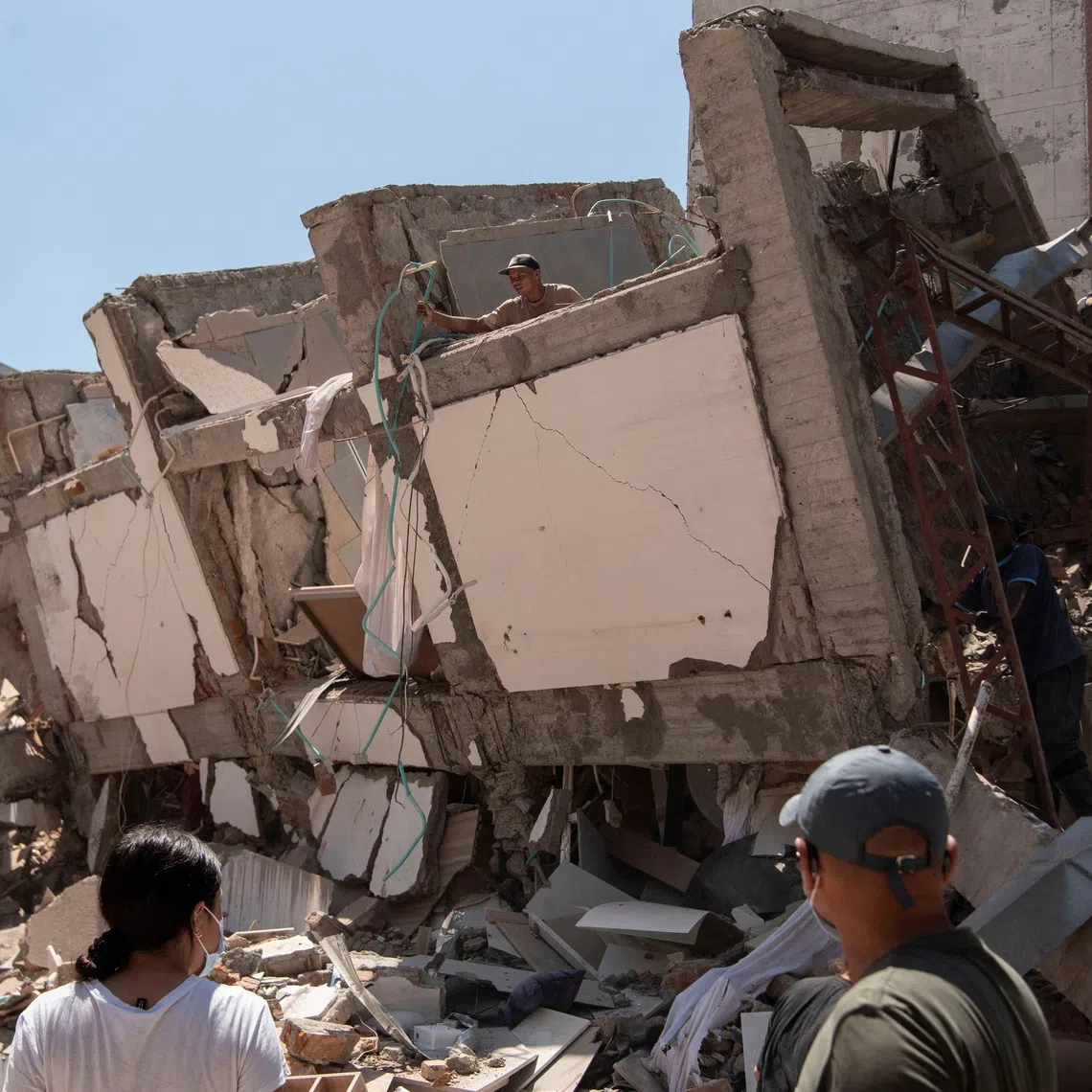 Residents dig through the debris of a damaged building after an earthquake in Cali, Colombia, on Aug 10.