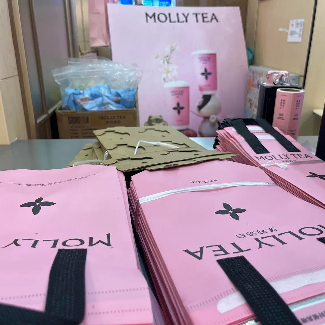 Packaging bags featuring Molly Tea’s logo, and display board of Molly Tea drinks, Kaide Mall (Sun Palace Shop) in Beijing, taken on July 8.
