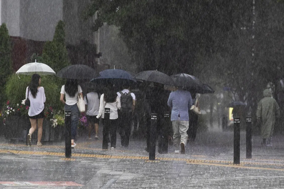 People walk with umbrellas amid heavy rain at Gwanghwamun Square in Seoul, South Korea, on July 17.