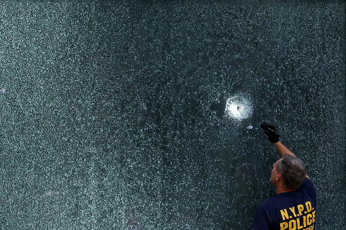 An NYPD Crime Scene Unit investigator inspecting a bullet hole at the scene of a deadly mass shooting in Manhattan, New York City, US, on July 29, 2025. 