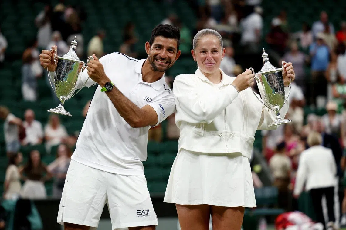 Tennis - Wimbledon - All England Lawn Tennis and Croquet Club, London, Britain - July 9, 2026  El Salvador's Marcelo Arevalo and Latvia's Jelena Ostapenko pose with the trophies after winning their mixed doubles final match against Australia's Marc Polmans and Australia's Storm Hunter REUTERS/Marko Djurica