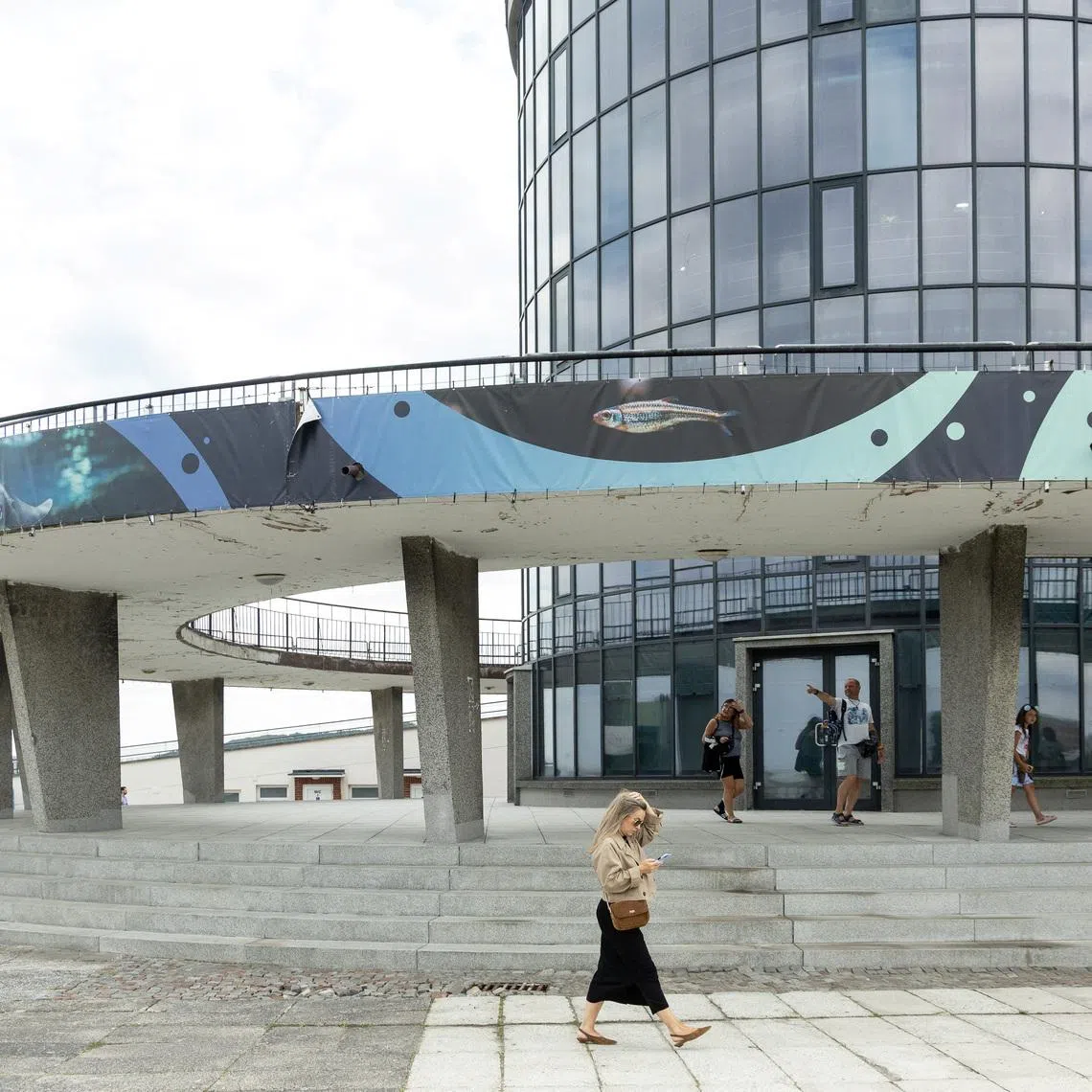People walk in front of the Gdynia Aquarium building, a site on the Gdynia Modernism Trail, in Gdynia, Poland, July 25, 2026. REUTERS/Lukasz Glowala
