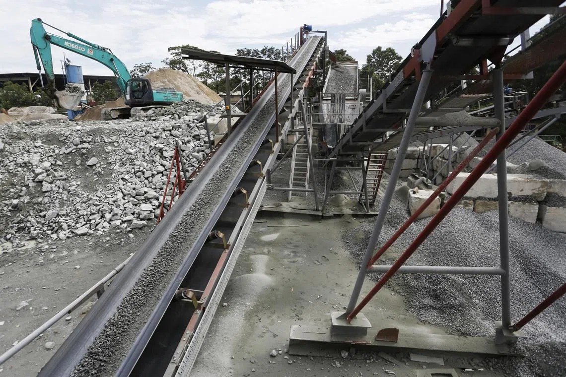 A conveyor belt delivers newly crushed rocks to be screened for sizes at Samwoh's recycling plant at the Sarimbun Recycling Park on 25 June 2014. The waste are processed into recycled concrete aggregate (RCA) and used for road construction and production of non-structural concrete.
