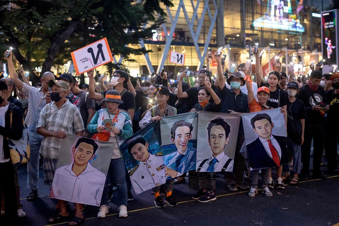Protesters hold up posters of Move Forward Party leader Pita Limjaroenrat during a demonstration in Bangkok on July 29.
