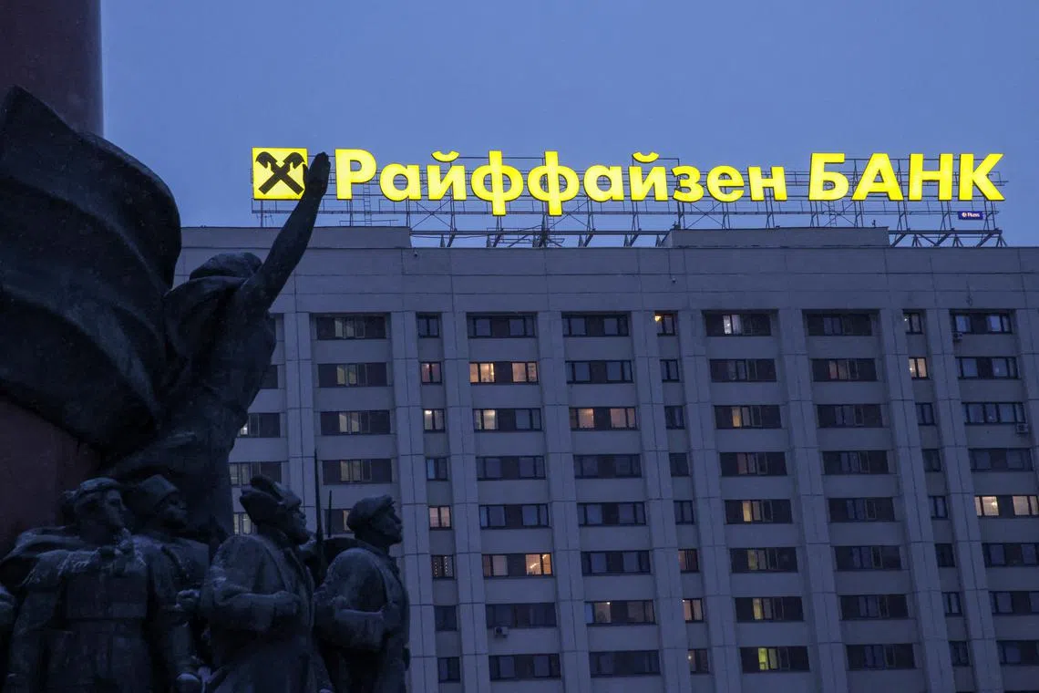 FILE PHOTO: A signboard advertising Raiffeisen Bank is seen behind figures of the 1917 Bolshevik Revolution participants, which form a fragment of a monument to Soviet state founder Vladimir Lenin, in Moscow, Russia, February 11, 2023. REUTERS/Tatyana Makeyeva/File Photo
