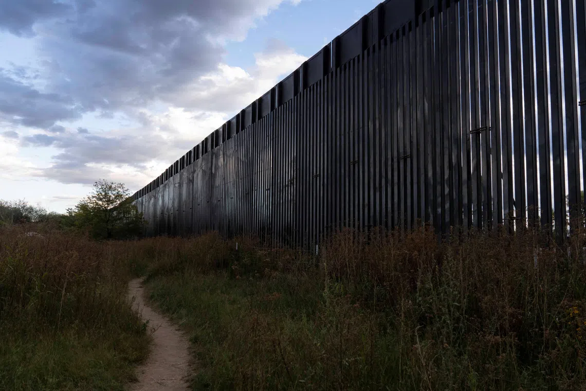 A footpath winds into the distance beside a section of the US-Mexico border fence constructed earlier in the day in Lochiel, Arizona, US October 8, 2026.  REUTERS/Rebecca Noble/File Photo