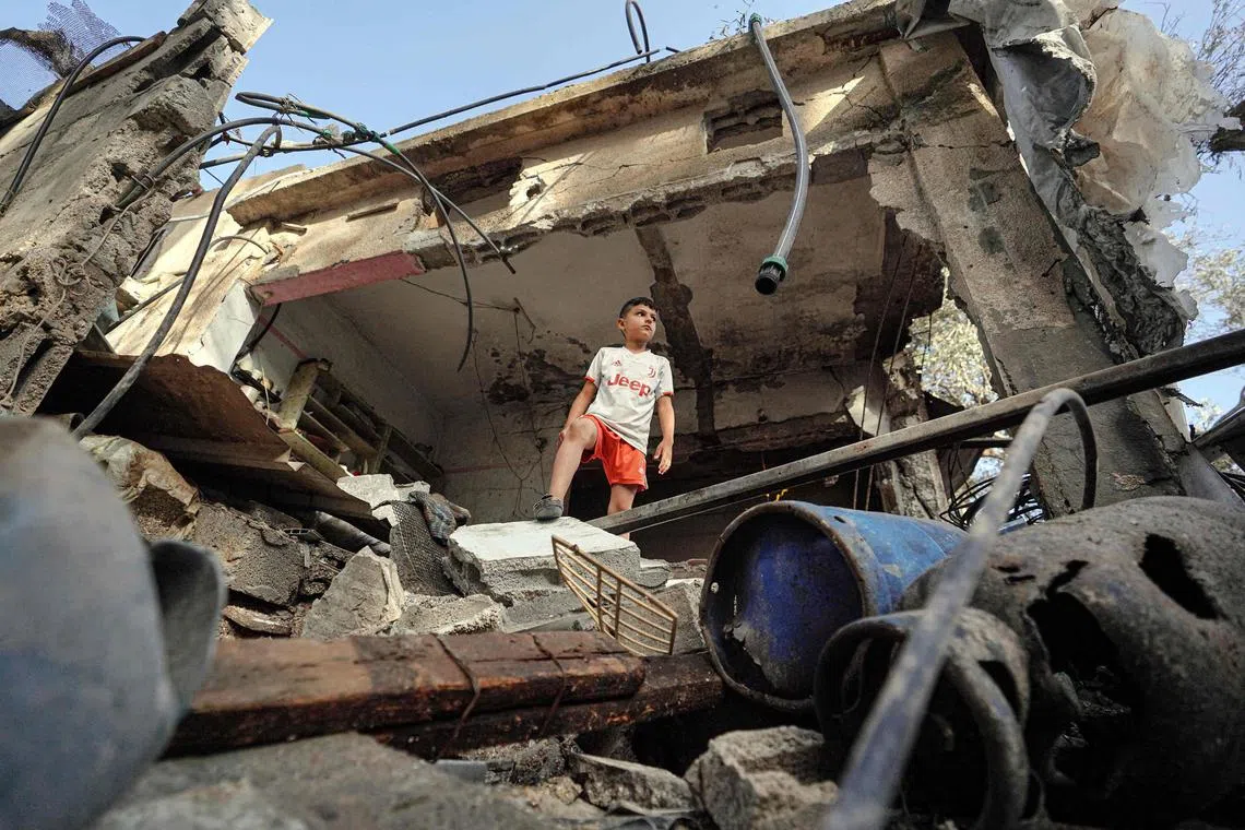 A Palestinian boy stands on the rubble of a destroyed house in Nuseirat following Israeli bombardment overnight on May 23.