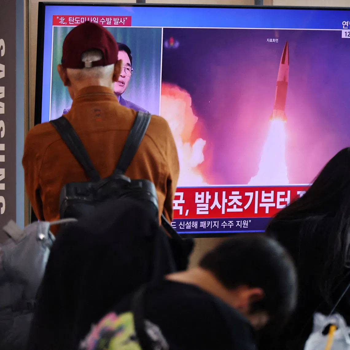 People watching a news report on North Korea firing multiple ballistic missiles toward the sea off its east coast, at a railway station in Seoul on Oct 12.