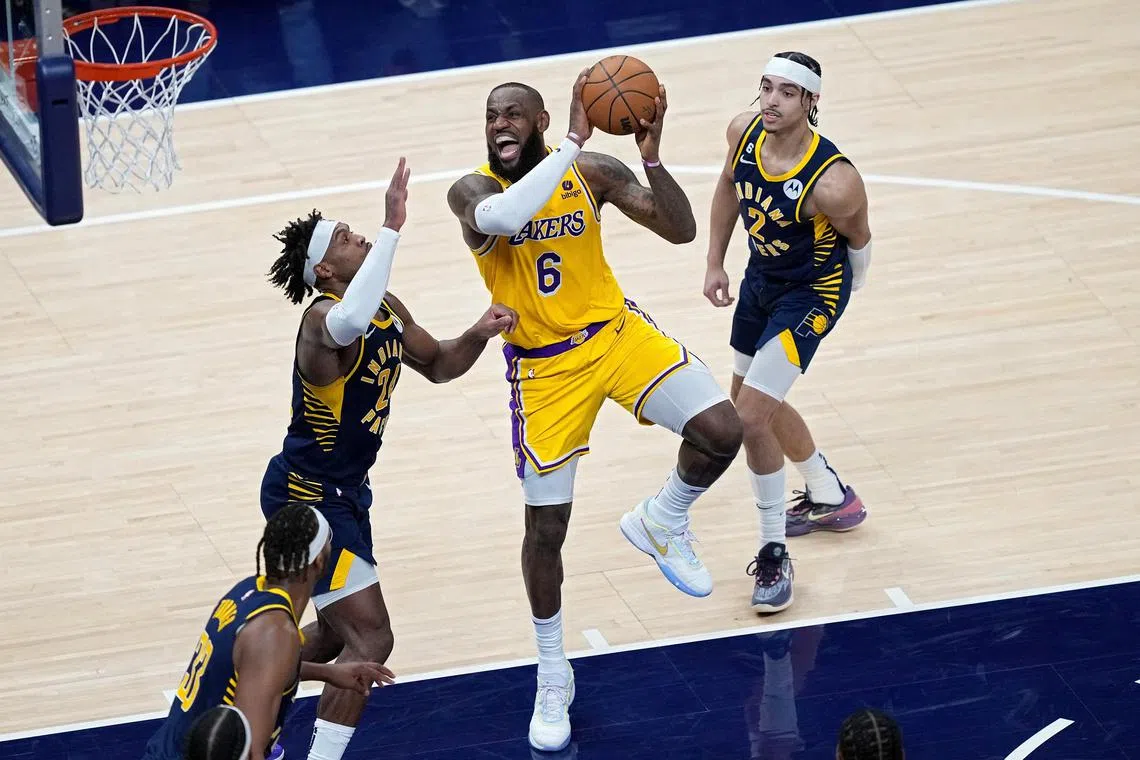 LeBron James of the Los Angeles Lakers attempting a shot while being guarded by Buddy Hield (No. 24) of the Indiana Pacers in Lakers' 112-111 win on Thursday.