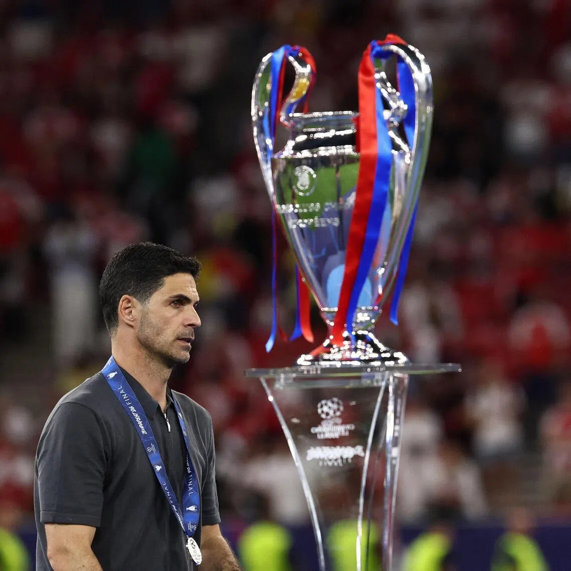Arsenal manager Mikel Arteta walking past the Champions League trophy after losing to Paris Saint-Germain on May 30.