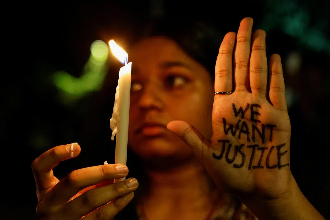 A woman attends a vigil condemning the rape and murder of a trainee medic at a government-run hospital in Kolkata.