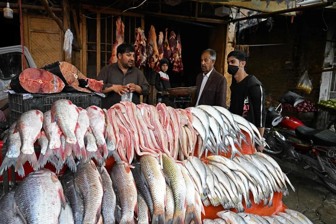 People buying fish and beef from a butcher's shop ahead of the Islamic holy fasting month of Ramadan in Quetta, Pakistan, on Feb 18, 2026. 