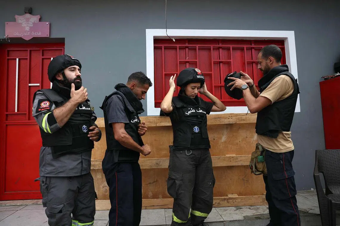 TOPSHOT - Members of Lebanon's Civil Defence prepare before responding to an emergency at their station in Beirut's Cola neighbourhood on October 13, 2024. Across the country, rescue workers are struggling to respond, with their resources already depleted by five years of economic crisis and fearing that they could be killed like dozens of colleagues over the past year. (Photo by IBRAHIM AMRO / AFP)