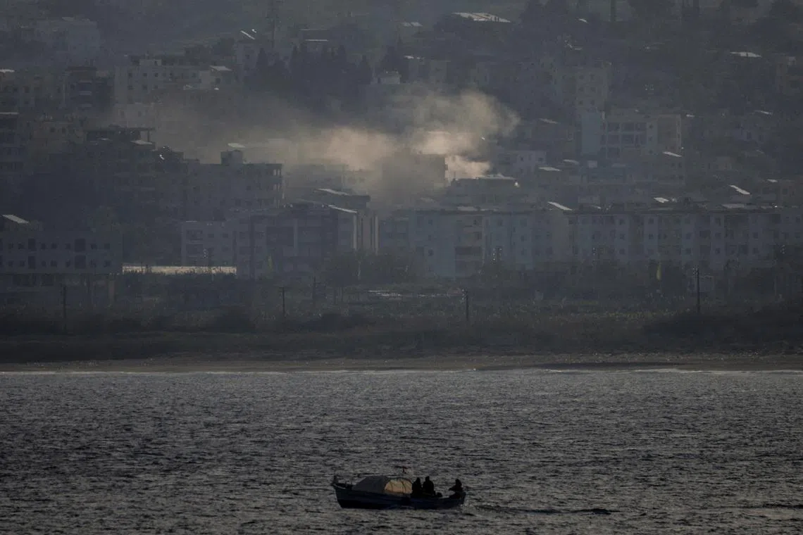 FILE PHOTO: Fishermen sail their boat as smoke from an Israeli airstrike rises in Abbassiye area in Tyre, Lebanon, April 14, 2026. REUTERS/Louisa Gouliamaki/File Photo
