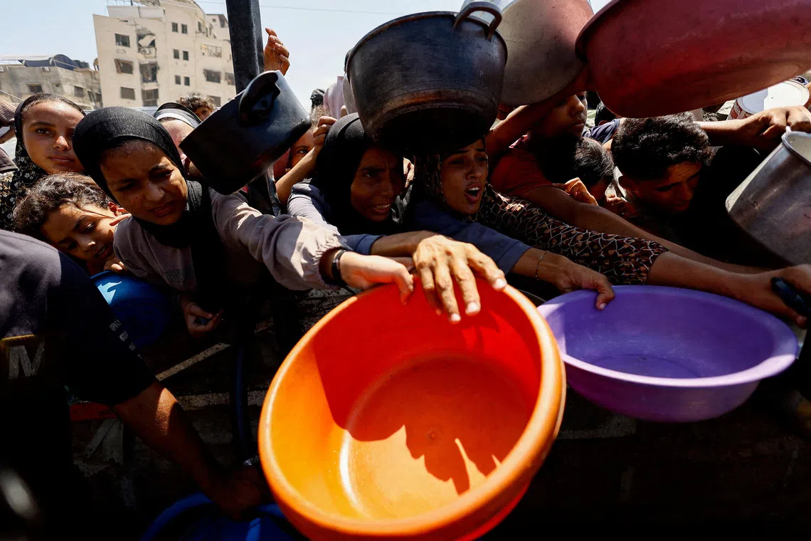 FILE PHOTO: Palestinians wait to receive food from a charity kitchen in Gaza City, August 28, 2025. REUTERS/Mahmoud Issa/File Photo