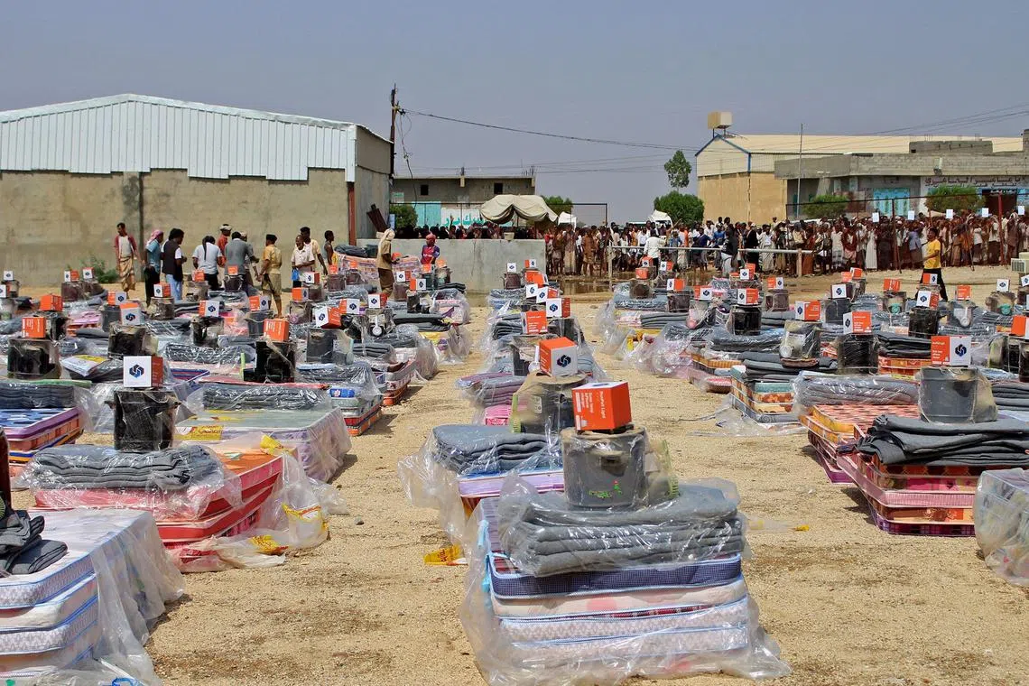 Displaced Yemenis receive essential aid provided by the Norwegian Council to support those affected by flooding, in the northern Abs district of the Hajjah governorate on September 16, 2023. Flooding and lightning strikes in Yemen have killed eight civilians, an official and a doctor said, underscoring the threat of extreme weather in the war-ravaged country. (Photo by ESSA AHMED / AFP)