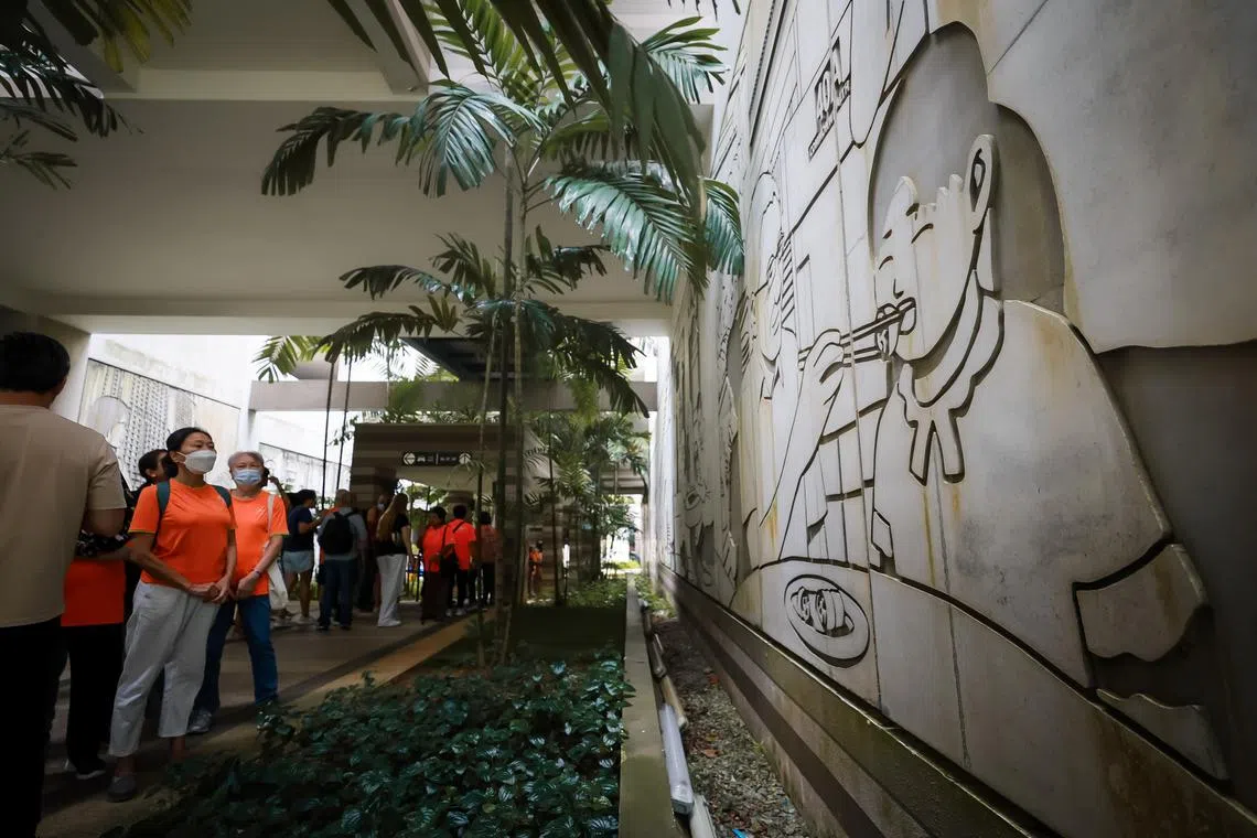 Seniors viewing wall murals by local artist Troy Chin during their walking tour of SkyVille@Dawson.