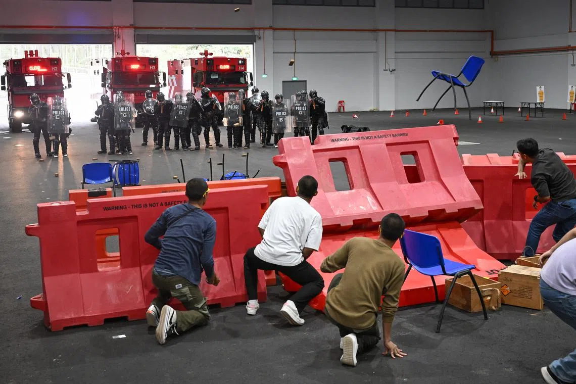 Amid a cacophony of jeers and shouts, around 20 ‘rioters’ pelted plastic chairs and wooden blocks at the media.