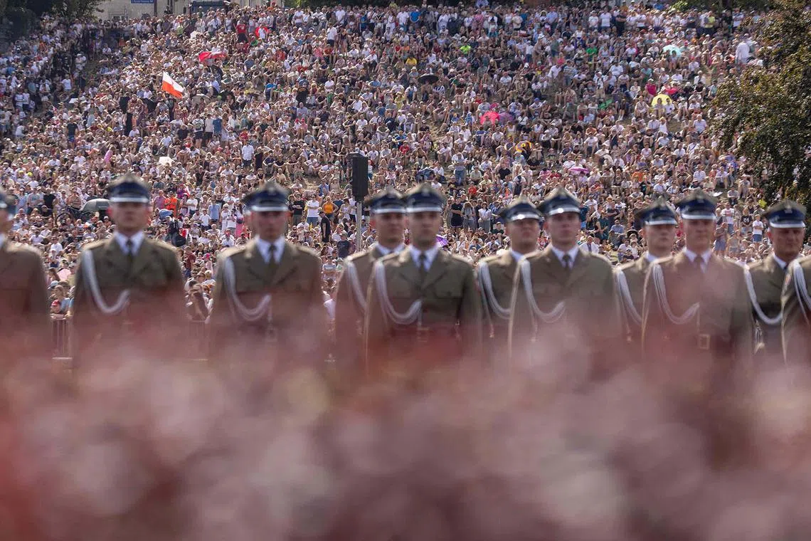 TOPSHOT - People gather to watch a military parade in Warsaw on Polish Army Day, August 15, 2024, to commemorate the anniversary of the 1920 victory over Soviet Russia at the Battle of Warsaw during the Polish–Soviet War. (Photo by Wojtek RADWANSKI / AFP)