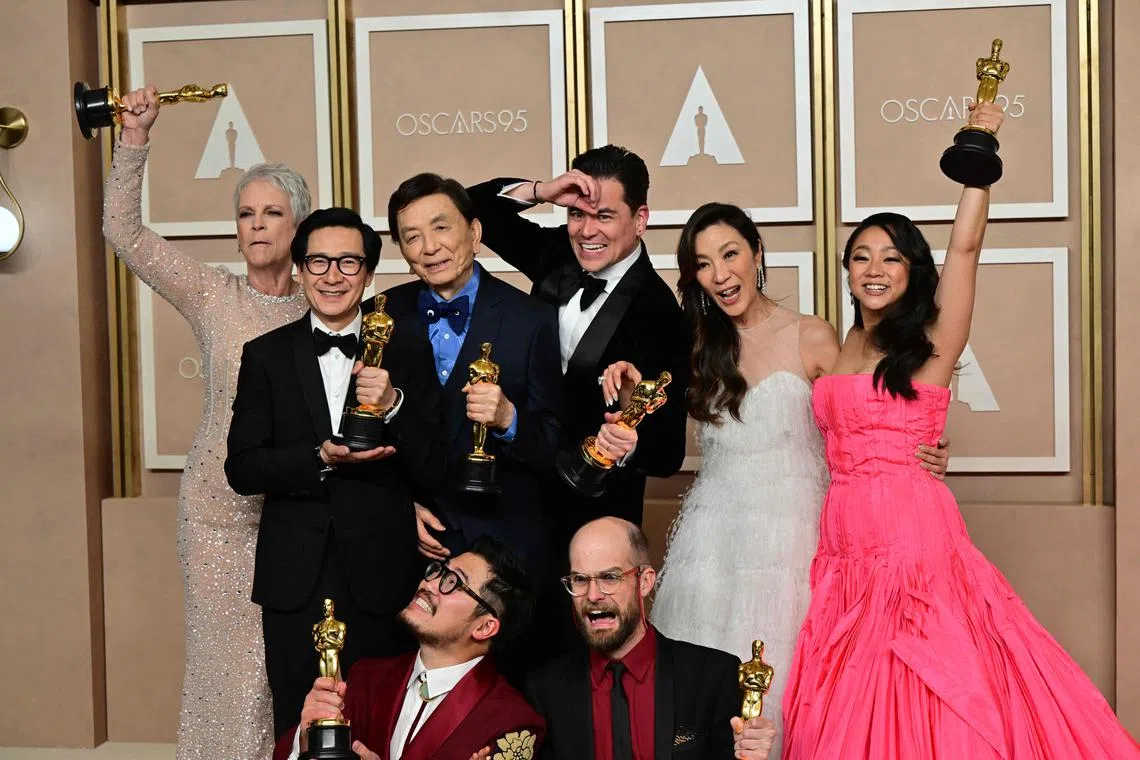 TOPSHOT - The cast and crew of "Everything Everywhere All at Once" Michelle Yeoh (2nd R), Ke Huy Quan (2nd L), Stephanie Hsu (R), Jamie Lee Curtis (L), James Hong (3rd L), Daniel Kwan (bottom L), Daniel Scheinert (bottom R), Jonathan Wang (C) pose with their Oscar trophies in the press room during the 95th Annual Academy Awards at the Dolby Theatre in Hollywood, California on March 12, 2023. "Everything Everywhere All At Once" producers Daniel Kwan, Daniel Scheinert and Jonathan Wang (Photo by Frederic J. Brown / AFP)