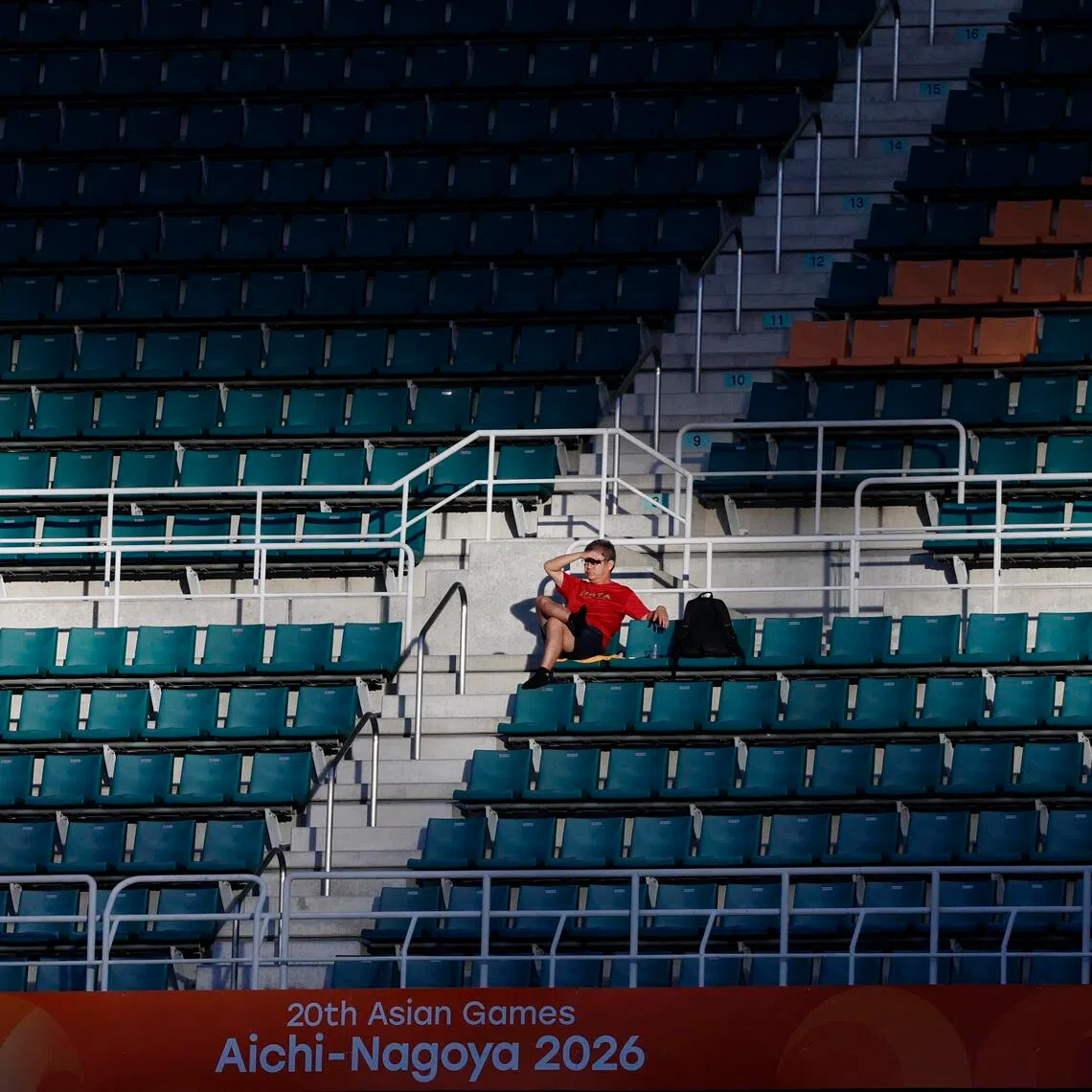 Asian Games - Aichi-Nagoya 2026 - Football - Group F - South Korea v North Korea - Shizuoka Stadium Ecopa, Fukuroi, Japan - September 21, 2026 General view as a fan sits amongst empty seats in the stands during the match REUTERS/Eloisa Lopez