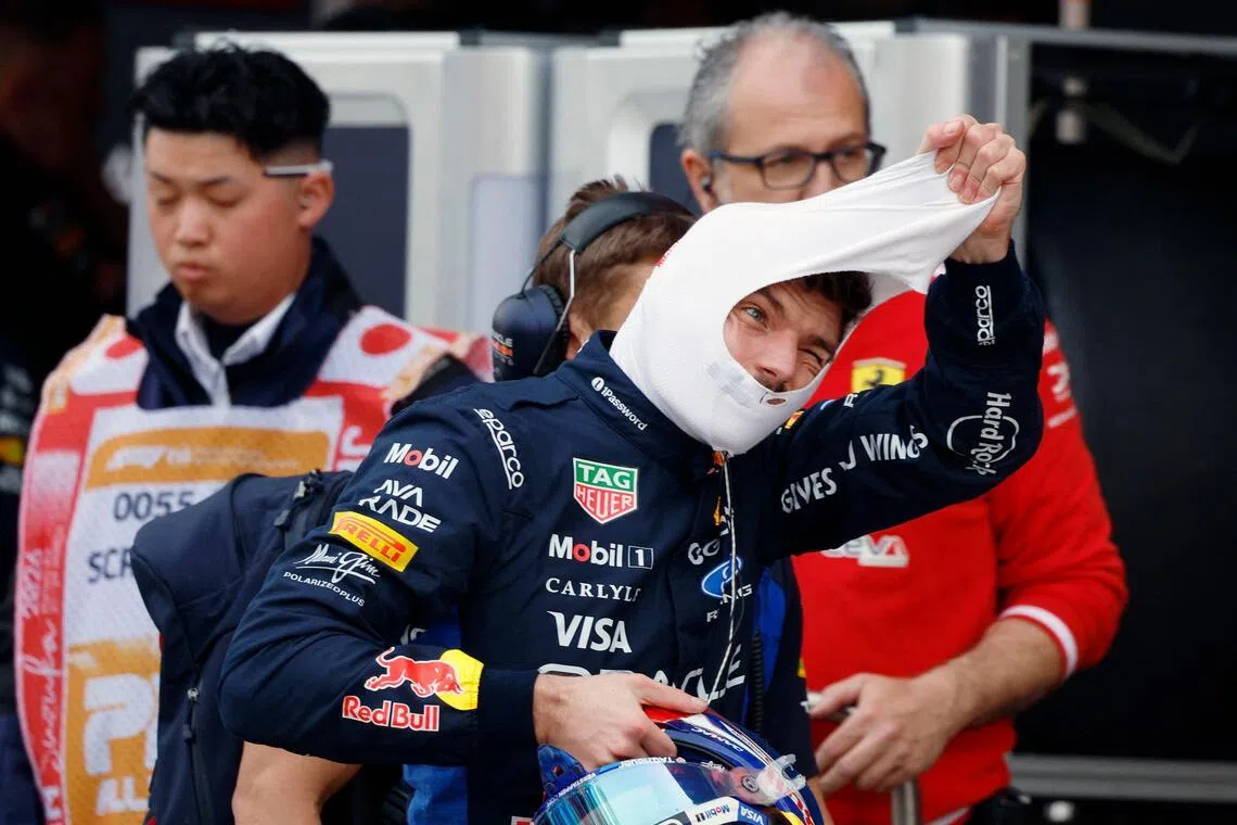 TOPSHOT - Red Bull Racing's Dutch driver Max Verstappen takes off his balaclava in the pits during the qualifying session ahead of the Formula One Japanese Grand Prix at the Suzuka circuit in Suzuka, Mie prefecture on March 28, 2026. (Photo by FRANCK ROBICHON / POOL / AFP)
