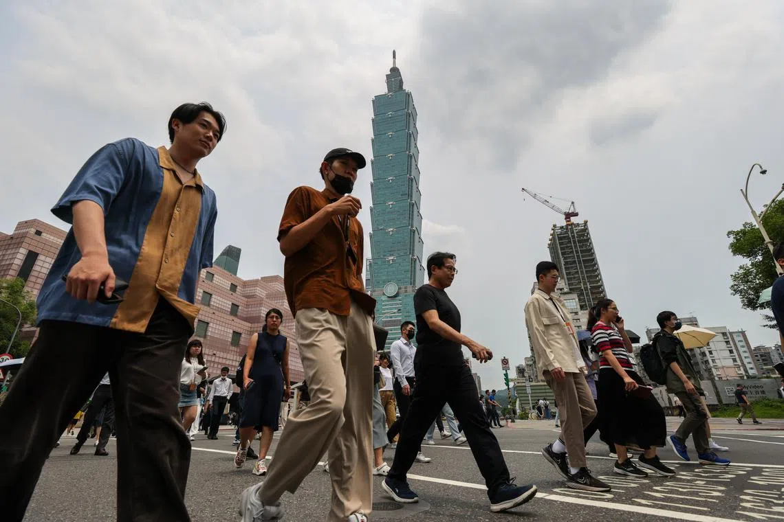 epa11309538 People walk across the street under Taipei 101 skyscraper building in Taipei, Taiwan, 30 April 2024. According to a statement recently released by the Taiwan Institute of Economic Research, Taiwan's Gross Domestic Product (GDP) growth forcast in 2024 is a rate of 3.29 percent, an increase of 0.14 percentage points from a previous forecast issued three months ago, driven by accelerated export growth even as private investment lags behind expectations.  EPA-EFE/RITCHIE B. TONGO
