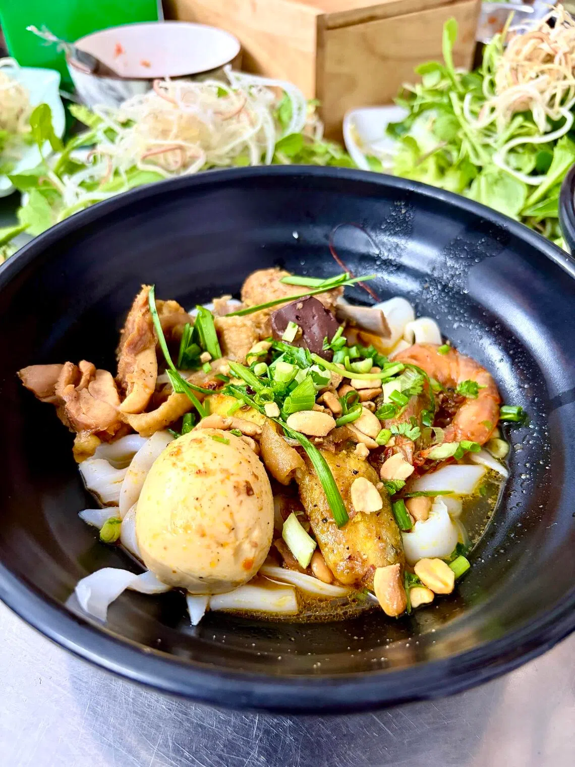 Mi quang features thick rice noodles drenched in a turmeric-tinged concentrated broth.