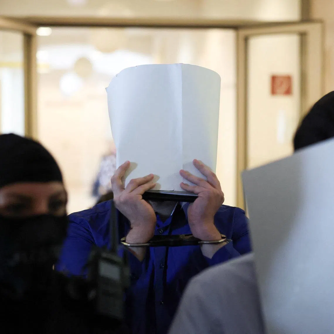 Two men suspected of being Islamic State (IS) supporters, who were planning an attack on Taylor Swift's Vienna concert in 2024, are escorted by security personnel as they arrive in a courtroom for their trial in Wiener Neustadt, Austria, April 28, 2026.REUTERS/Leonhard Foeger