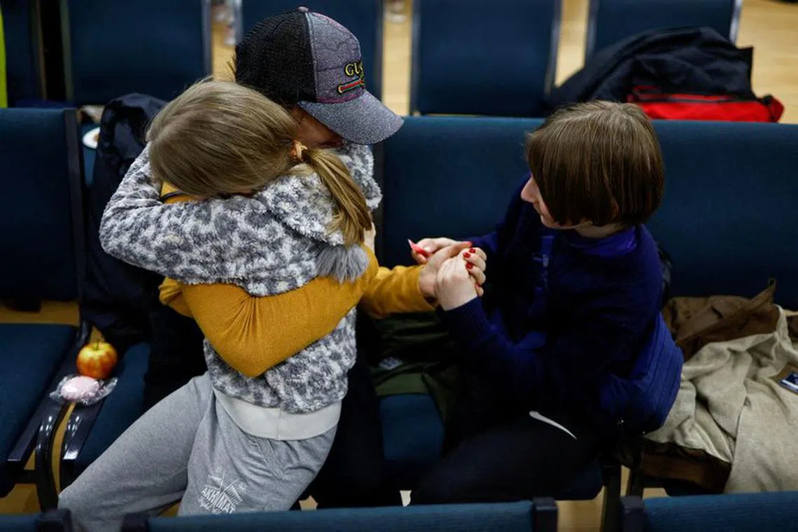 FILE PHOTO: Anastasiia holds her daughter Valeriia and son Maksym, who went to a Russian-organised summer camp from non-government controlled territories and were then taken to Russia, after they returned via the Ukraine-Belarus border, in Kyiv, Ukraine April 8, 2023. REUTERS/Valentyn Ogirenko/File Photo