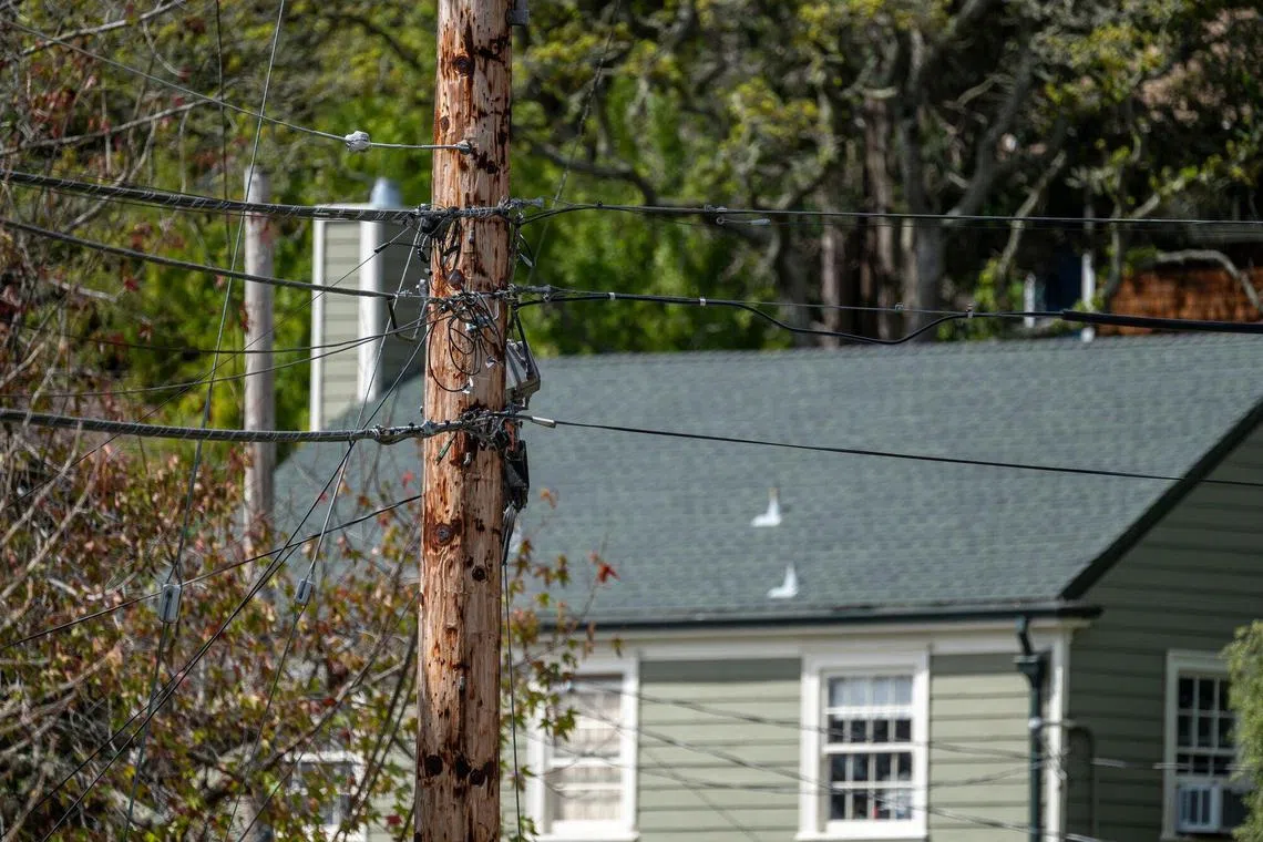Power lines in front of homes in Berkeley, California, US, on Thursday, March 28, 2024. US home insurance rates are expected to reach a record high this year, with the biggest increases occurring in states prone to severe weather events, according to a new analysis. Photographer: David Paul Morris/Bloomberg