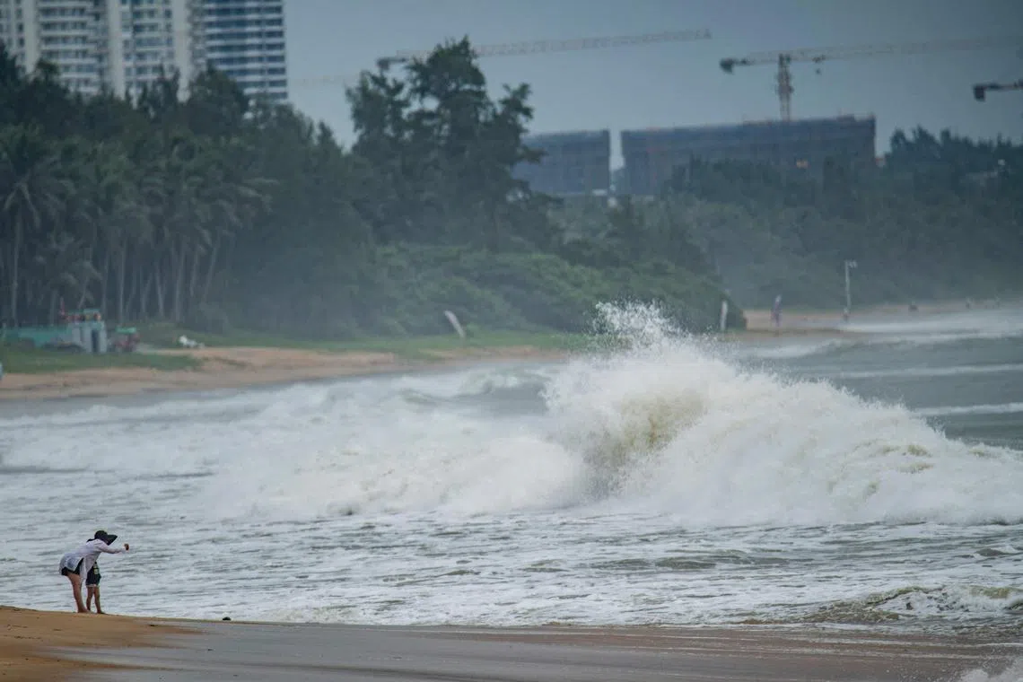 People watch big waves at a sea shore as Typhoon Talim approaches in Boao, in China's southern Hainan province on July 17, 2023. (Photo by CNS / AFP) / China OUT