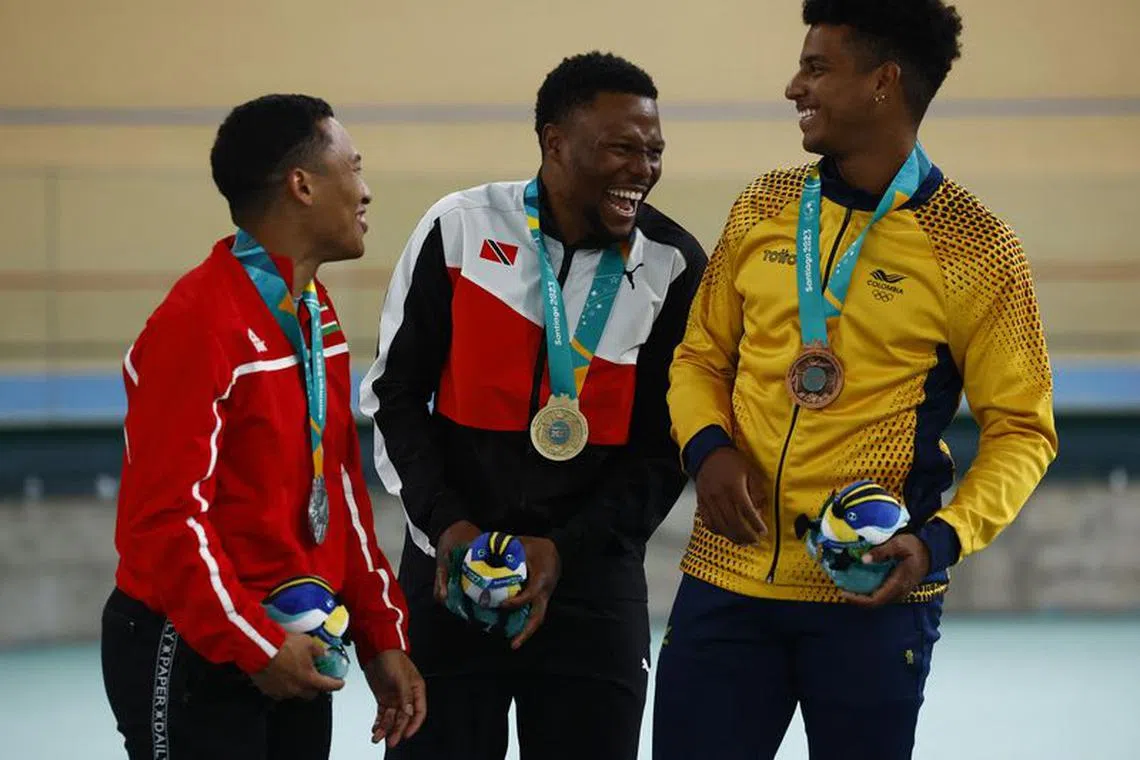 Pan-Am Games - Santiago 2023 - Cycling - Velodromo Penaloen, Santiago, Chile - October 26, 2023 Gold medallist Trinidad and Tobago's Nicholas Lee Paul celebrates on the podium with his medal after winning the men's sprint gold medal final alongside Silver medallist Suriname's Jair Tjon En Fa and Bronze medallist Colombia's Kevin Santiago Quintero Chavarro REUTERS/Agustin Marcarian